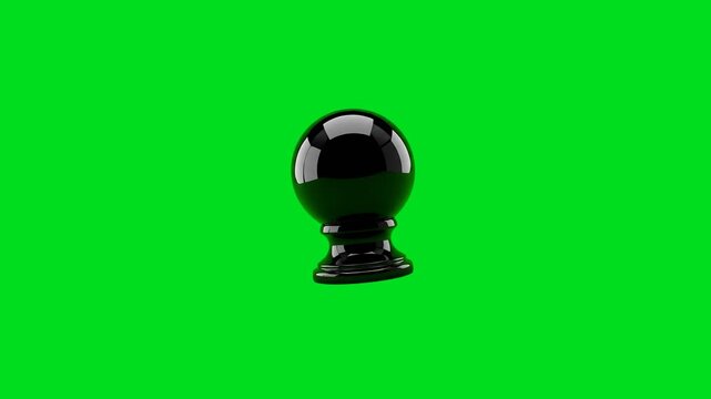 A shiny black spherical object isolated against a vibrant green background