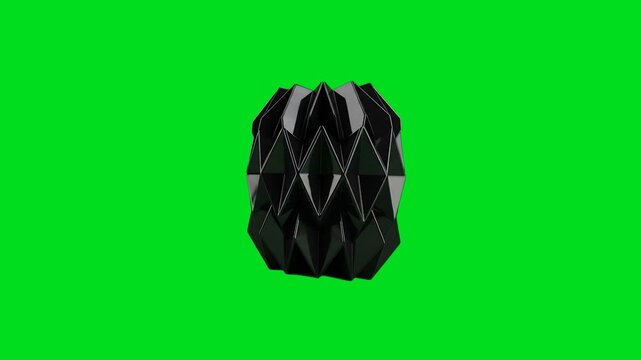 A glossy black geometric object isolated against a vibrant green screen background