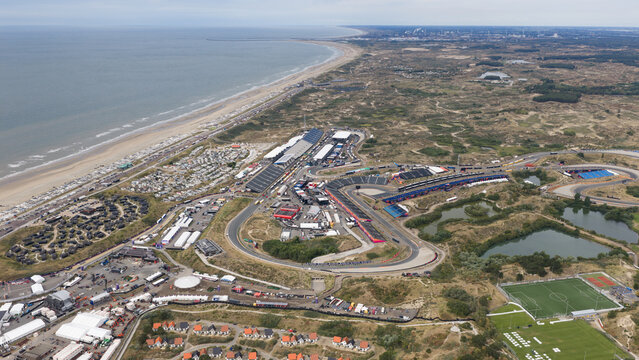 Zandvoort, North Holland, Netherlands - 16 August 2026: Aerial view of Circuit Zandvoort, a motor racing track nestled among coastal dunes, with grandstands and the North Sea coastline.