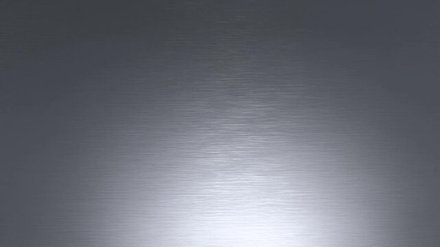 Brushed metal surface with soft central illumination and subtle tonal variation across a neutral gray background