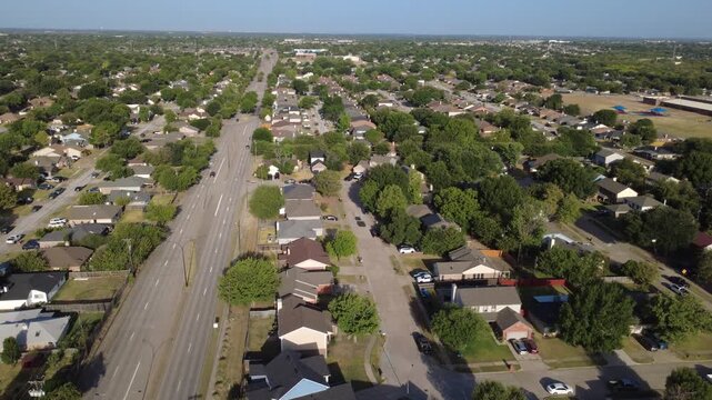 Lush suburban tree lines flank Southeast Parkway commuter corridor beside Charles City tracts. Multi lane asphalt thoroughfares pass tidy single story brick dwellings, Arlington, Texas