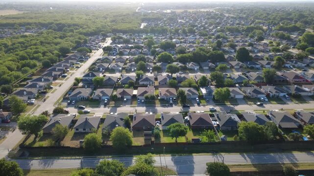 Neat single story brick dwellings line Charles City subdivision avenues. Tidy fenced lawns face Southeast Parkway corridor under clear afternoon skies, paved driveways, Arlington, Texas