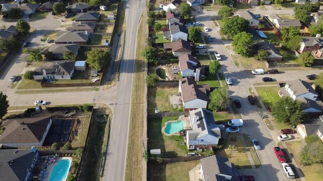 Paved two lane thoroughfares divide Charles City properties from Nicole Court tracts. Custom swimming pools sit beside rooftop solar arrays, secure fenced boundaries, Arlington, Texas
