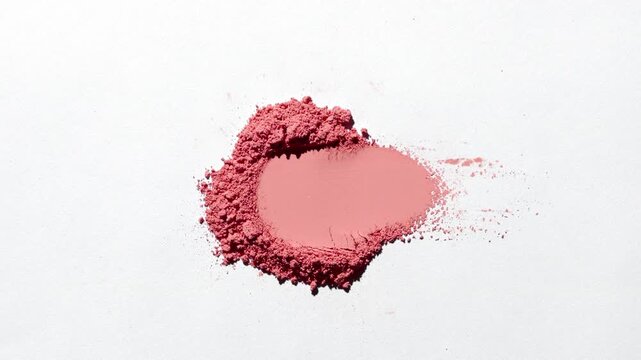 Top-down capture of a red smeared powder heap on a gentle grey background illuminated by rotating light projecting dynamic, shifting shadows | Concept idea for blush marketing