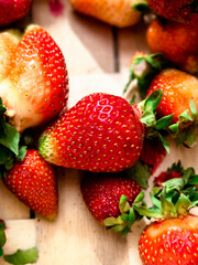 Fresh Ripe Strawberries with Green Stems on a Light Wooden Surface, Cl © Marcin