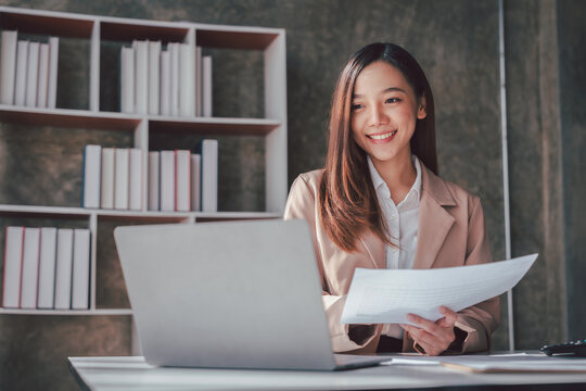 Asian Women Working Analysis Financial Report with Laptop for Bu