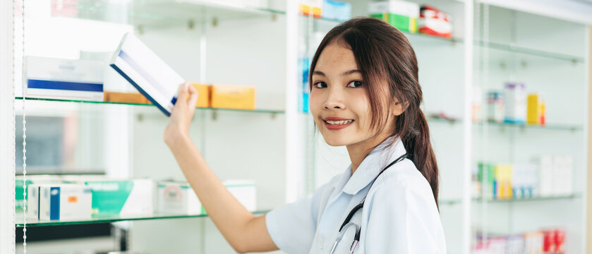 A woman is smiling and holding a box of medicine
