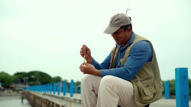 Senior man preparing fishing gear by the seaside. Retirement lifestyle active aging. Healthy longevity, outdoor recreation, peaceful leisure. Life insurance planning for a secure retirement.
