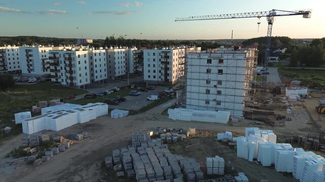 Construction Site with Crane and Apartment Building Under Development at Sunset &mdash; Aerial View