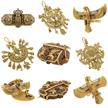 Collection of ornate gold jewelry with gemstones, including pendants, brooches, and boxes, isolated on a white background.