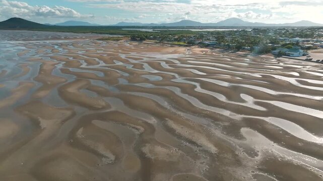 Aerial view of tidal sand flats and coastal landscape in Bowen, Queensland, Australia.