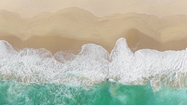 Aerial footage of Praia de Traba beach in Spain, showing turquoise ocean waves rolling onto a sandy shore.