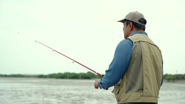 Happy senior man fishing by the sea during retirement. Active aging, outdoor leisure healthy longevity. Independence, retirement lifestyle, life insurance. Financial security for a fulfilling future.
