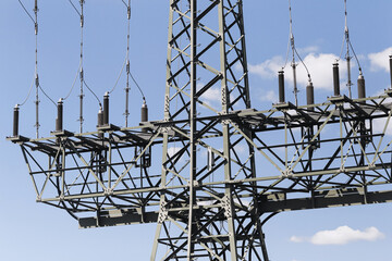 Electrical substation stands under blue sky. Steel framework holds insulators. Power lines connect grid equipment. Energy infrastructure supports industry. Electricity forms technical background. © Paweł Michałowski