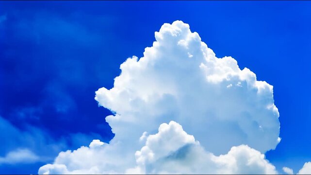 Fluffy white cumulus clouds drift and evolve against a vibrant deep blue sky.