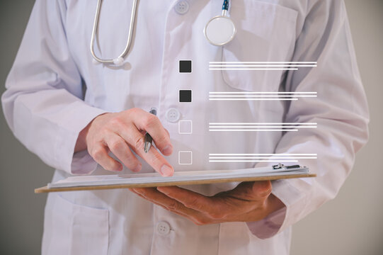 Male doctor wearing white cloth and stethoscope using pen and paper report analysing patient diagnosis data in medicine and healthcare concept
