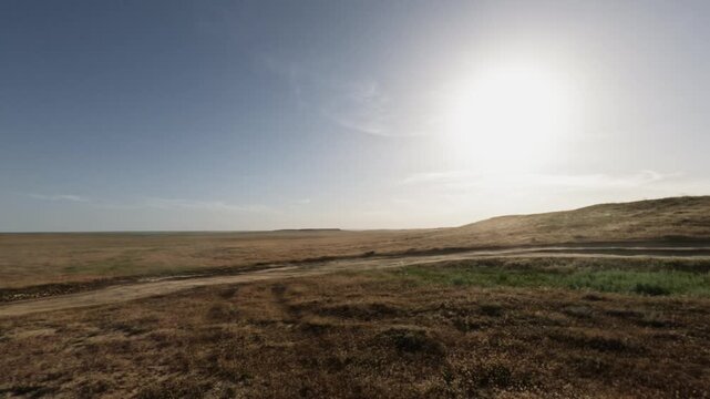 Off-road vehicle traverses open landscape, showcasing speed and terrain changes