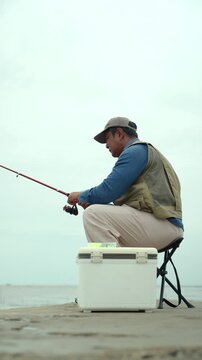 Happy senior man fishing by the sea during retirement. Active aging, outdoor leisure healthy longevity. Independence, retirement lifestyle, life insurance. Financial security for a fulfilling future.
