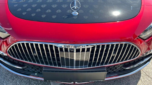 Red Mercedes-Maybach front grille with illuminated hood emblem and chrome detailing. Premium automotive styling, prestige, and performance. Gdansk, Poland - May 10, 2026.