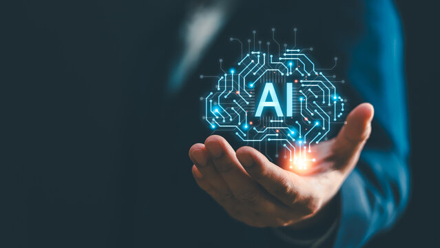 Businessman hand holding glowing digital brain icon with AI text. Concept of artificial intelligence, machine learning, technology innovation, future business analysis, and cyber network data