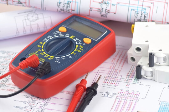 The digital multimeter electrical engineering drawings, circuit breaker and pencils.