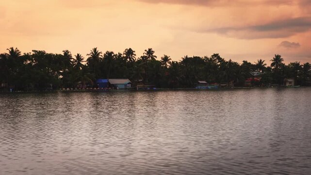 Beautiful boat ride through the serene backwaters of Kochi, Kerala, at sunset, surrounded by coconut palms, calm water, and lush tropical scenery, showcasing the peaceful beauty of South India.