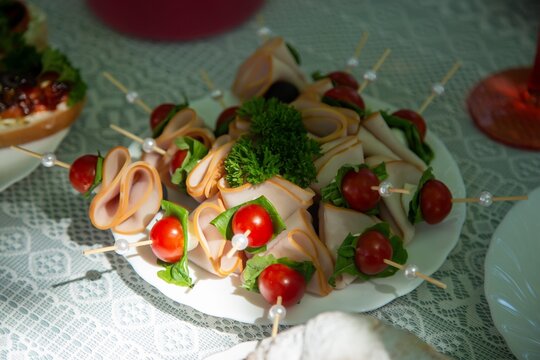  Skewered appetizers with deli meat, cherry tomatoes, and lettuce on a plate. Perfect for parties and gatherings, offering a colorful and inviting presentation of finger foods
