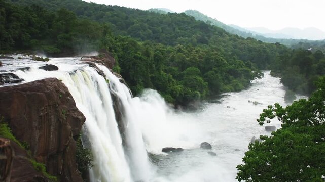 Majestic Athirappilly Waterfalls cascading with powerful monsoon flow through the lush tropical rainforest of Kerala, India, it is one of the most spectacular attractions of the Western Ghats