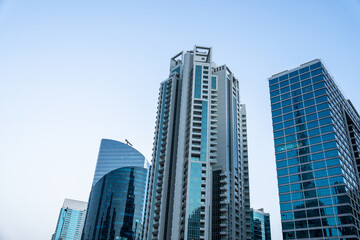 Fototapeta premium A view of skyscrapers. A business center in a big city, a tall building covered in glass windows.
