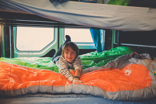 Children, having fun in camper van while heavy raining outdoors, playing and making mischiefs