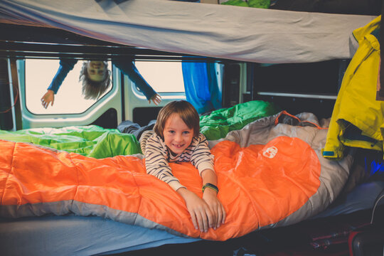 Children, having fun in camper van while heavy raining outdoors, playing and making mischiefs