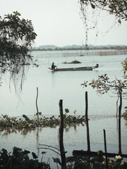 Fototapeta premium Cambodian fisher on long tranditional fishing boat near tonle sap lake Siem Reap Cambodia