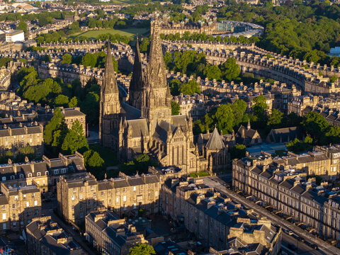 Aerial view of St Mary's Cathedral surrounded by historic stone buildings and lush trees in the city center of Edinburgh, Scotland, United Kingdom.