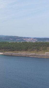 Vertical 9:16 aerial video showing the scenic coastline of Praia de Melide in Cangas, Spain.