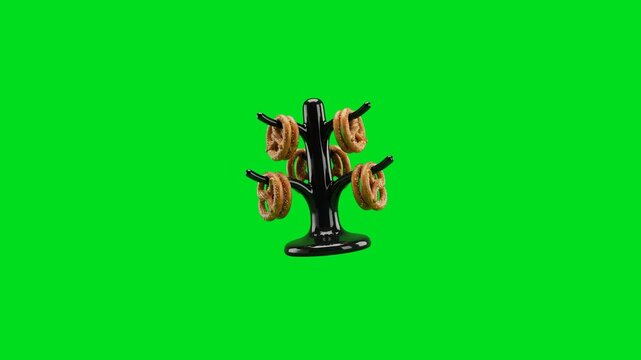 A shiny black ceramic pretzel tree display isolated on a vibrant green screen