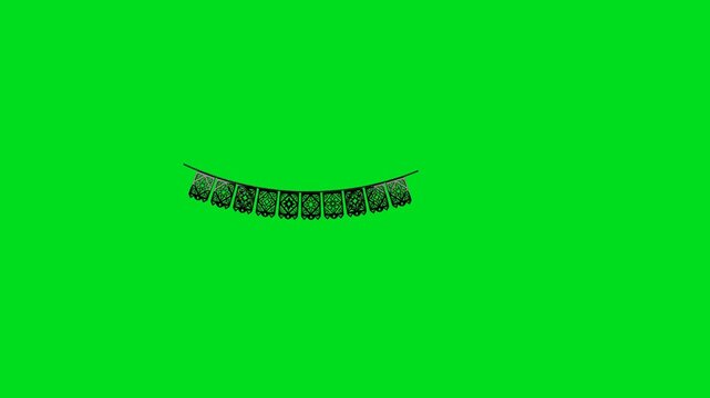 A string of decorative black paper papel picado hanging on a green background