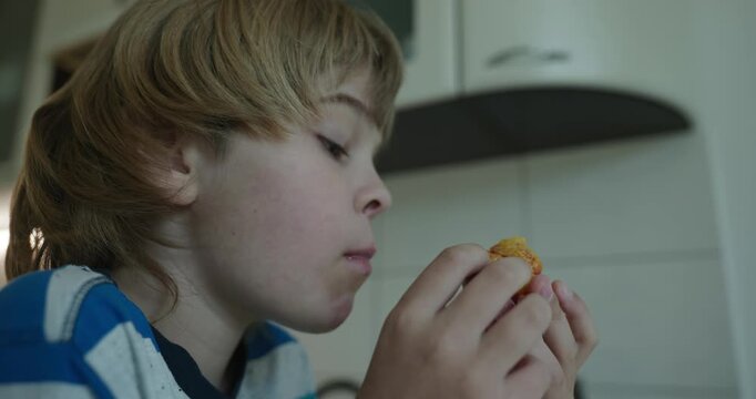 Caucasian kid boy enjoy eating peach in kitchen. 4K 10-bit