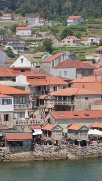 Vertical 9:16 video showing the picturesque waterfront of Combarro, Spain. The scene captures the unique coastal architecture and charm of this Spanish village.