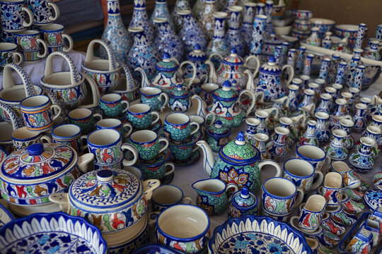 View of traditional hand-painted blue and green ceramic pottery including teapots, cups, and plates displayed at a market in Lahore, Punjab, Pakistan.
