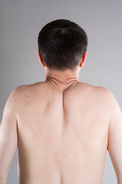 Unrecognizable shirtless man suffering from neck and shoulder pain. Tense trapezius muscle. Office syndrome and backache medical concept