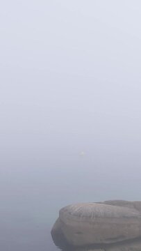 A vertical 9:16 video showing dense morning fog gradually clearing over Praia das Pipas beach in O Grove, Galicia, Spain.