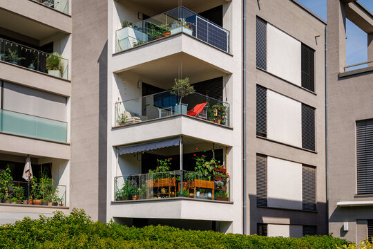 Balcony garden setup in a modern apartment building during a sunny day