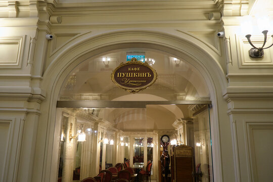 Ornate entrance to an elegant historic cafe Pushkin with arched doorway, decorative molding, chandeliers, mirrors, and classic interior design - Moscow, Russia, August 11, 2026