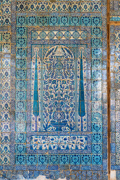 View of the intricate blue Iznik tilework featuring floral motifs and cypress trees inside the historic Aqsunqur Mosque in El-Darb El-Ahmar, Cairo Governorate, Egypt.