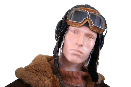 Man mannequin head wearing vintage leather aviator cap and flight goggles. Retro military pilot costume isolated on transparent background. Historical aviation style and air transport gear.
