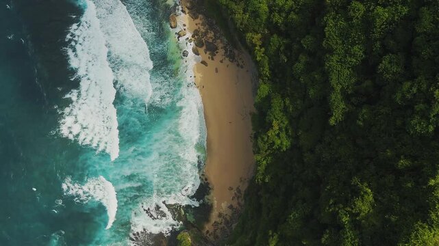 Breathtaking aerial flyover above an exotic hidden bay in Uluwatu South Bali &ndash; Spectacular cinematic drone shot of pristine turquoise reef, steep rocky cliffs and secluded sandy beach background 4k