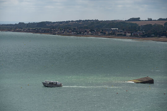 Arromanches-les-Bains, France - 08 10 2026: D-Day boat tours. View of Archimed amphibious vessel navigating around the rest of the artificial harbor in the sea