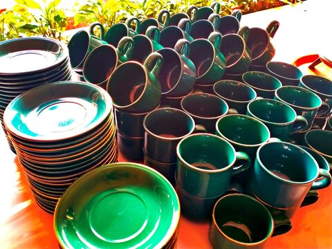 Green Ceramic Cups and Saucers Stacked for Coffee and Tea Tableware