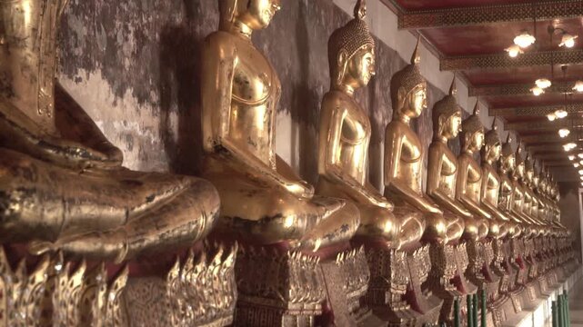 Row of ancient buddha statues in buddhist temple
