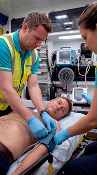 Medical emergency: a paramedic team attends to a patient in an ambulance and takes their blood pressure.
